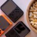Close-up of retro handheld game consoles and popcorn, perfect for gaming nights.